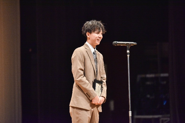 スーツを着て立っている男性
中程度の精度で自動的に生成された説明